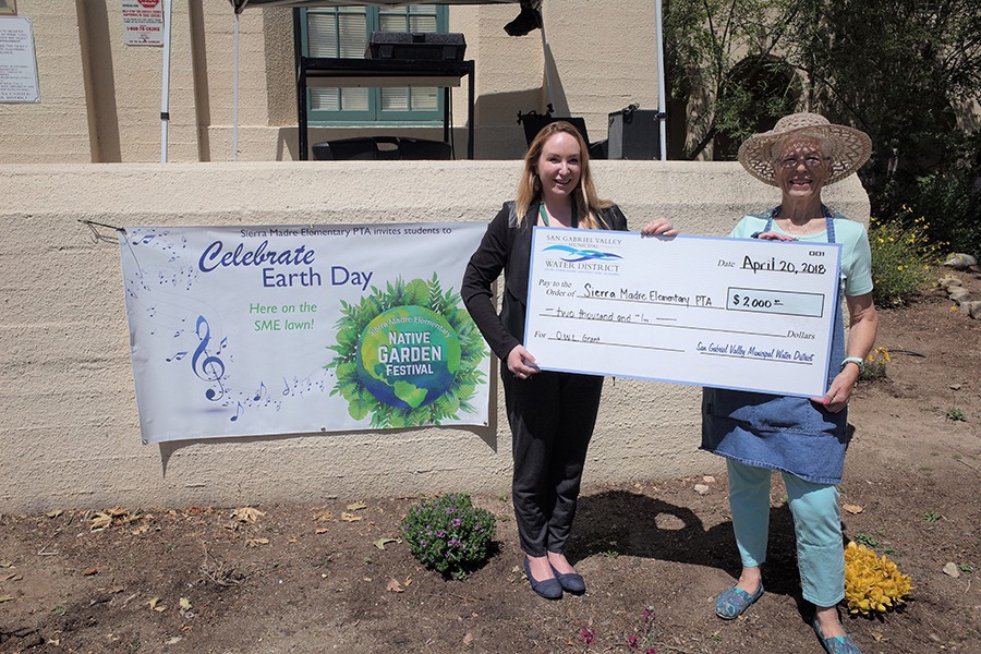 Two women holding a check for Sierra Madre Elementary School PTA at Earth Day Festival for the OWL Grant